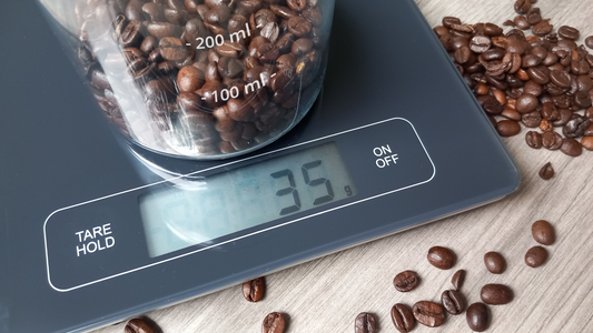 Wagge mit einem Messbecher, gefüllt mir Kaffeebohnen
