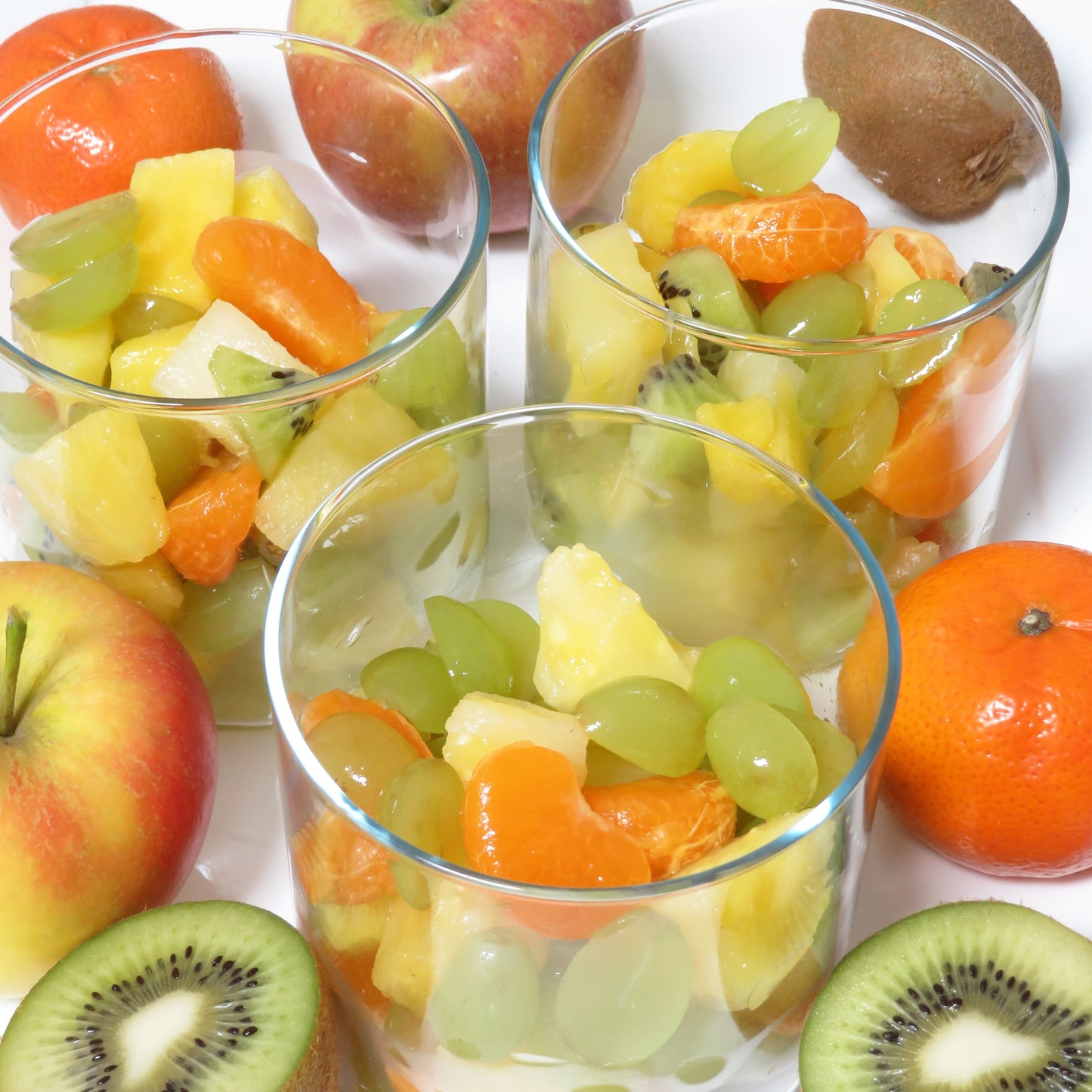 3 kleine Meal Prep Vorratsgläser, gefüllt mit Obstsalat, Kiwi, Mandarine, Apfel